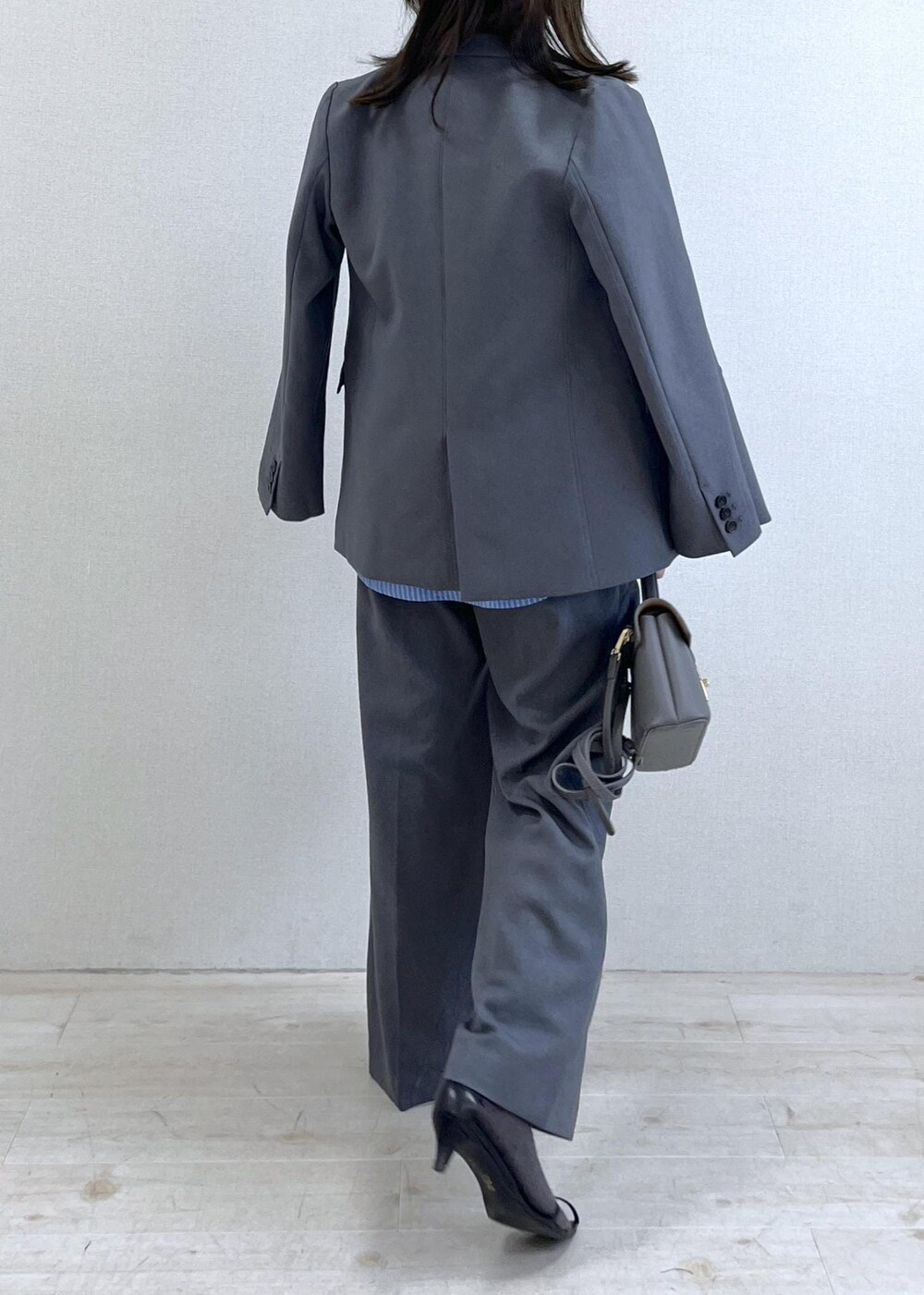 グレー系のショルダーバッグ、ブルー系のシャツ/ブラウス、ホワイト系のニット/セーターを着用したレディースの秋コーディネートの4枚目の写真