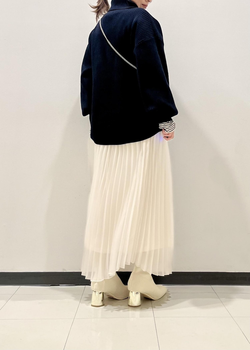 ホワイト系のブーツ、ホワイト系のニット/セーター、ブルー系のニット/セーターを着用したレディースの冬コーディネートの3枚目の写真