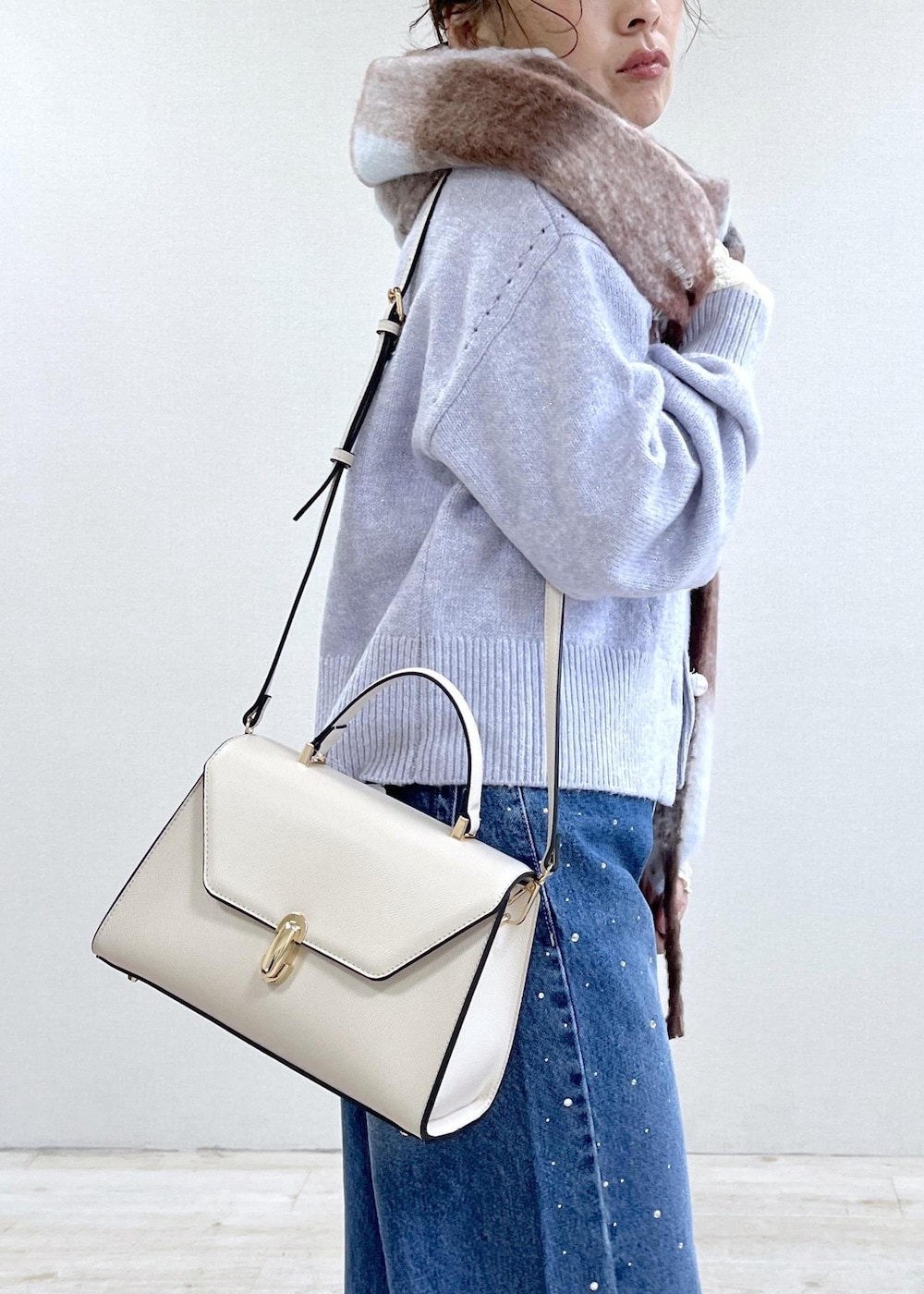 パープル系のカーディガン/ボレロ、ホワイト系のTシャツ/カットソー、ブラック系のブーツを着用したレディースの秋コーディネートの5枚目の写真