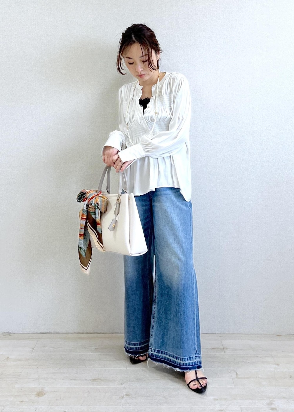 ブラック系のキャミソール、ブルー系のデニムパンツ、ブラック系のカーディガン/ボレロを着用したレディースの春コーディネートの6枚目の写真