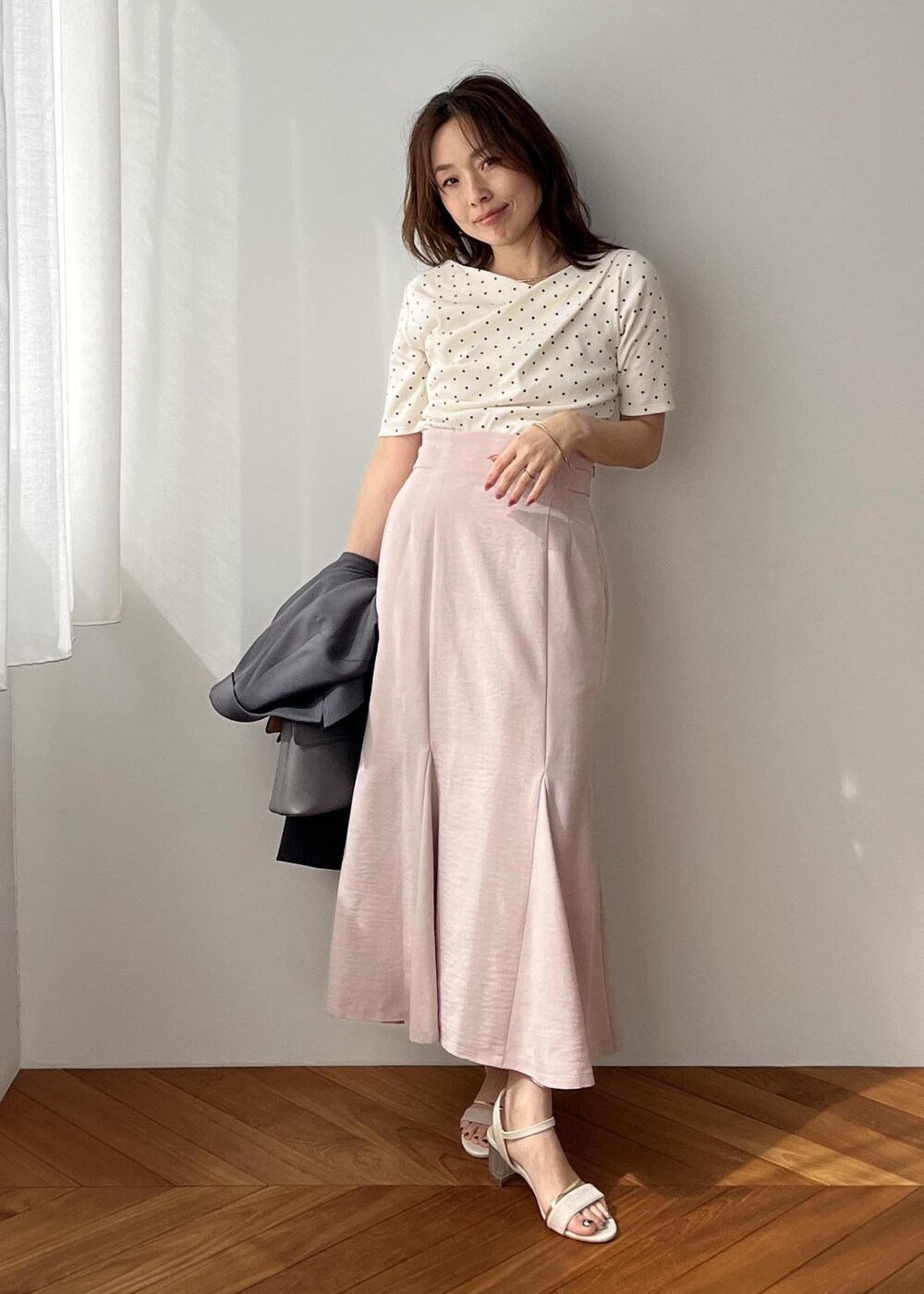 グレー系のショルダーバッグ、グレー系のテーラードジャケット、ピンク系のスカートを着用したレディースの春コーディネートの9枚目の写真