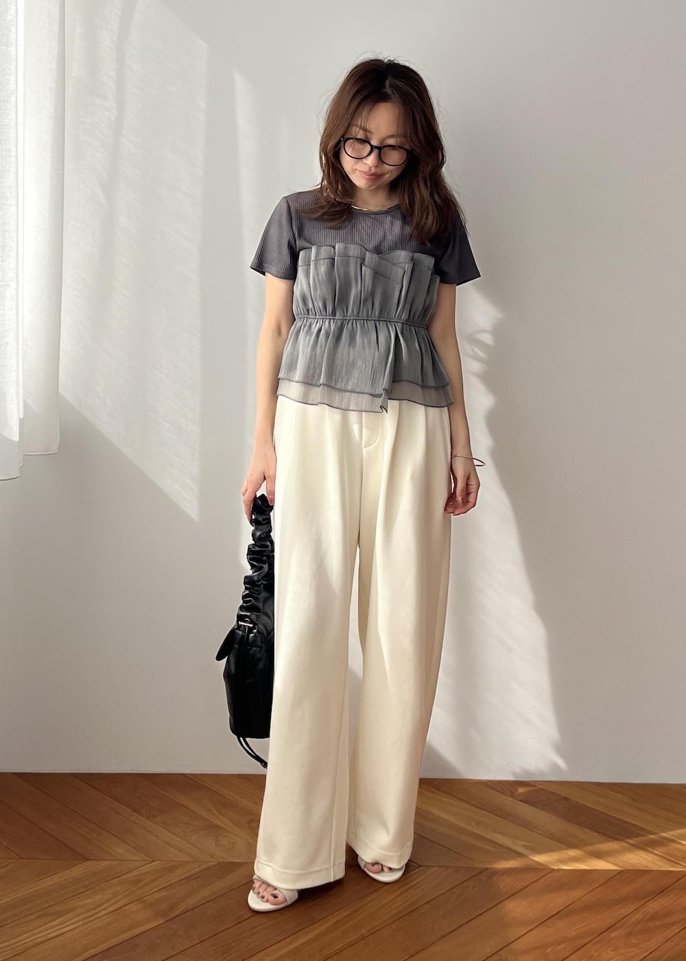 ホワイト系のスラックス、ブラック系のショルダーバッグ、ホワイト系のサンダルを着用したレディースの春コーディネートの8枚目の写真