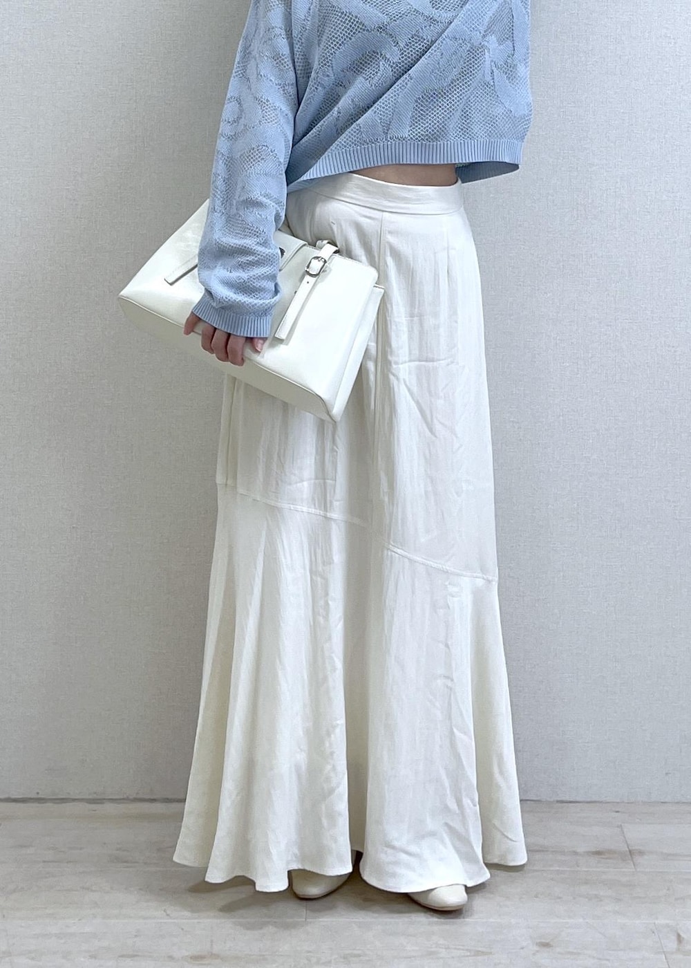 ブラック系のキャミソール、ホワイト系のパンプス、ホワイト系のスカートを着用したレディースの春コーディネートの2枚目の写真