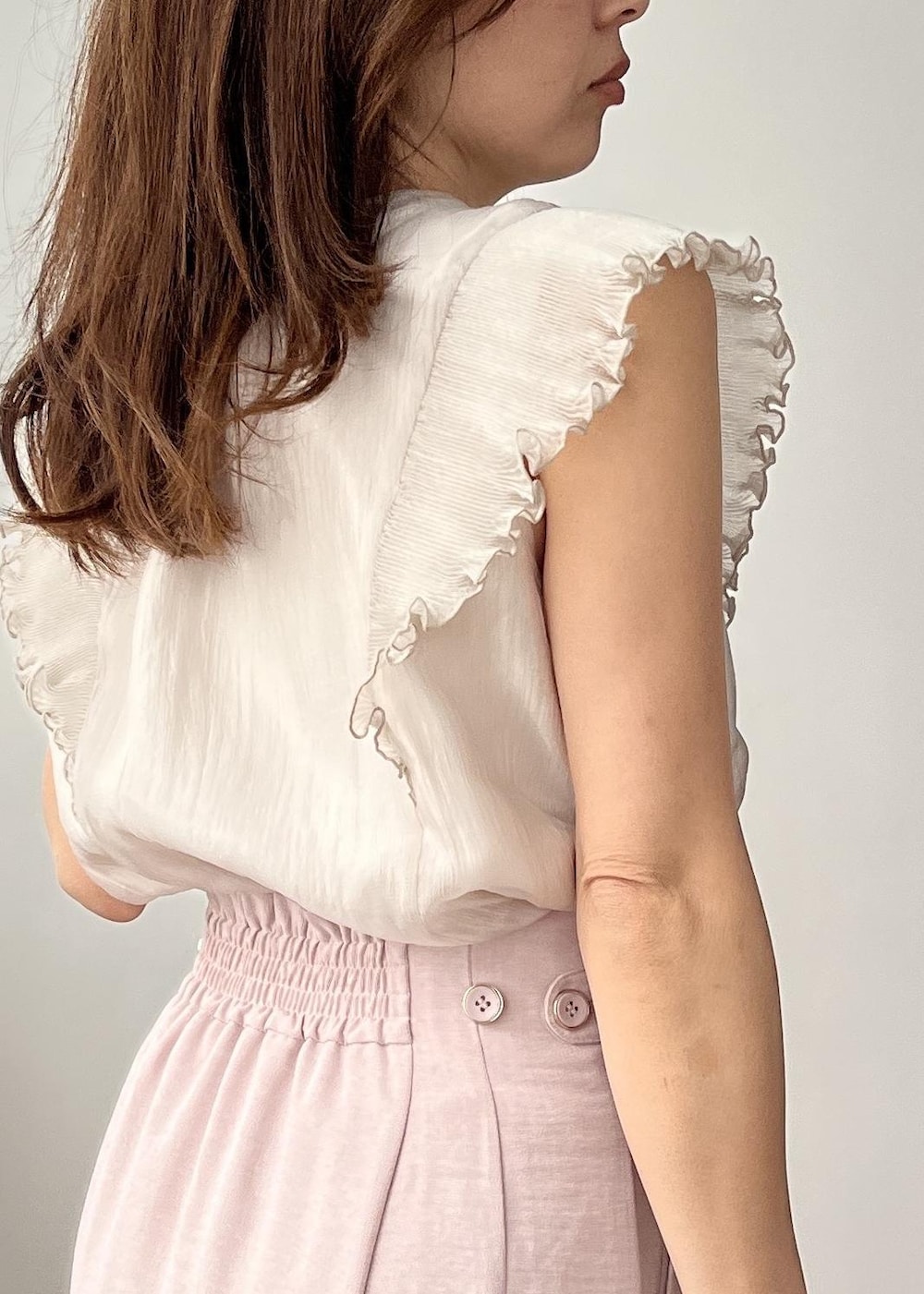 ベージュ系のショルダーバッグ、ピンク系のスカート、ホワイト系のサンダルを着用したレディースの春コーディネートの6枚目の写真