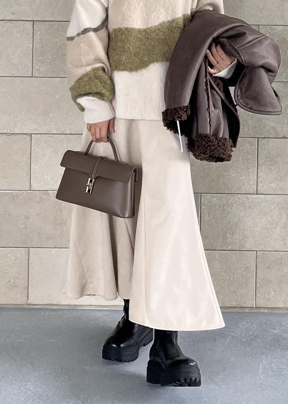 ベージュ系のショルダーバッグ、ブラック系のブーツ、ブラウン系のブルゾンを着用したレディースの秋コーディネートの8枚目の写真