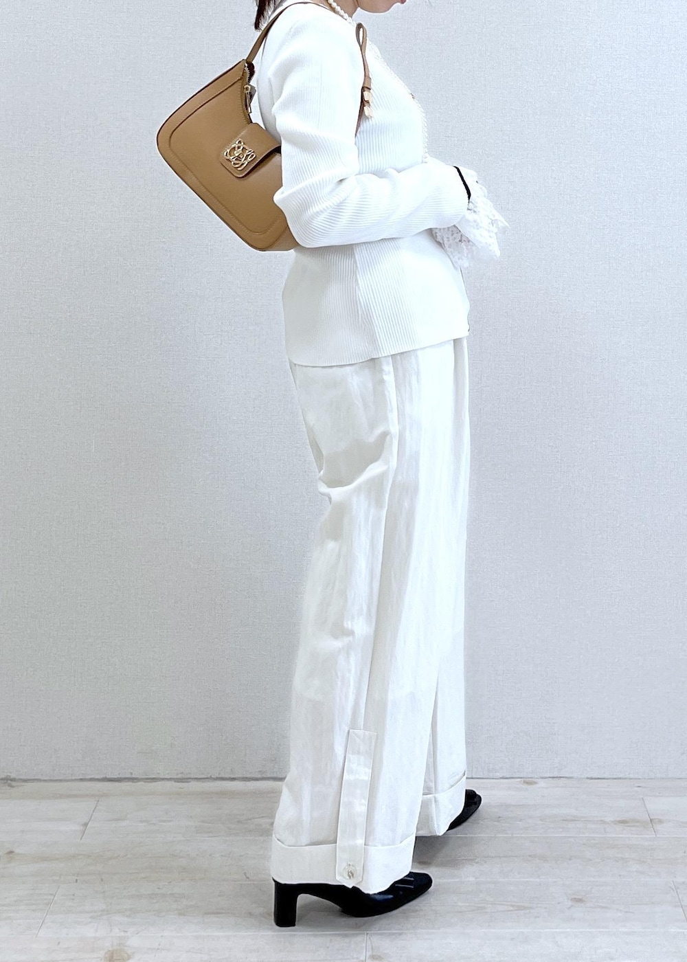 ブラック系のパンプス、ブルー系のテーラードジャケット、イエロー系のショルダーバッグを着用したレディースの冬コーディネートの8枚目の写真