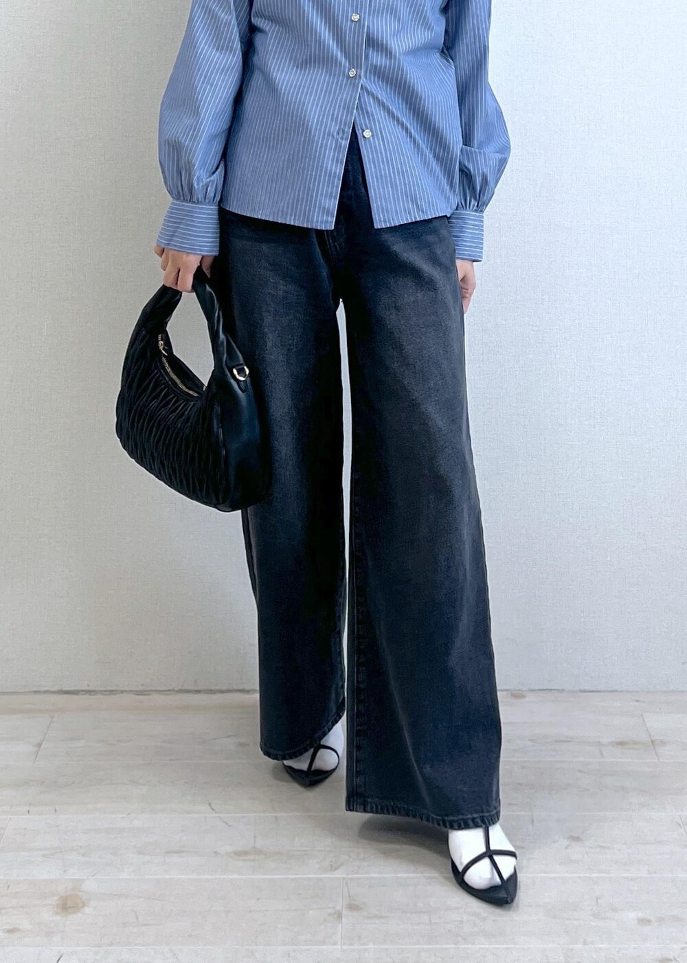 ブルー系のシャツ/ブラウス、グレー系のデニムパンツ、ブラック系のハンドバッグを着用したレディースの秋コーディネートの2枚目の写真