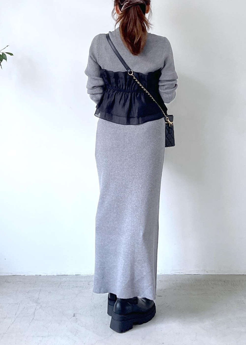 ブラック系のブーツ、グレー系のスカート、グレー系のニット/セーターを着用したレディースの秋コーディネートの5枚目の写真