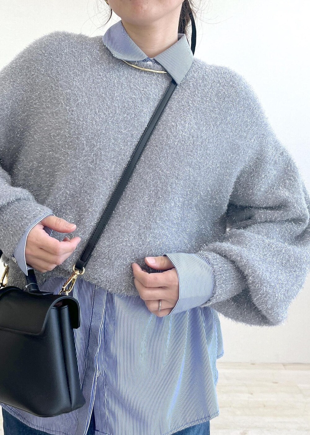 シルバー系のショルダーバッグ、ブラック系のスラックス、ブルー系のシャツ/ブラウスを着用したレディースの冬コーディネートの6枚目の写真