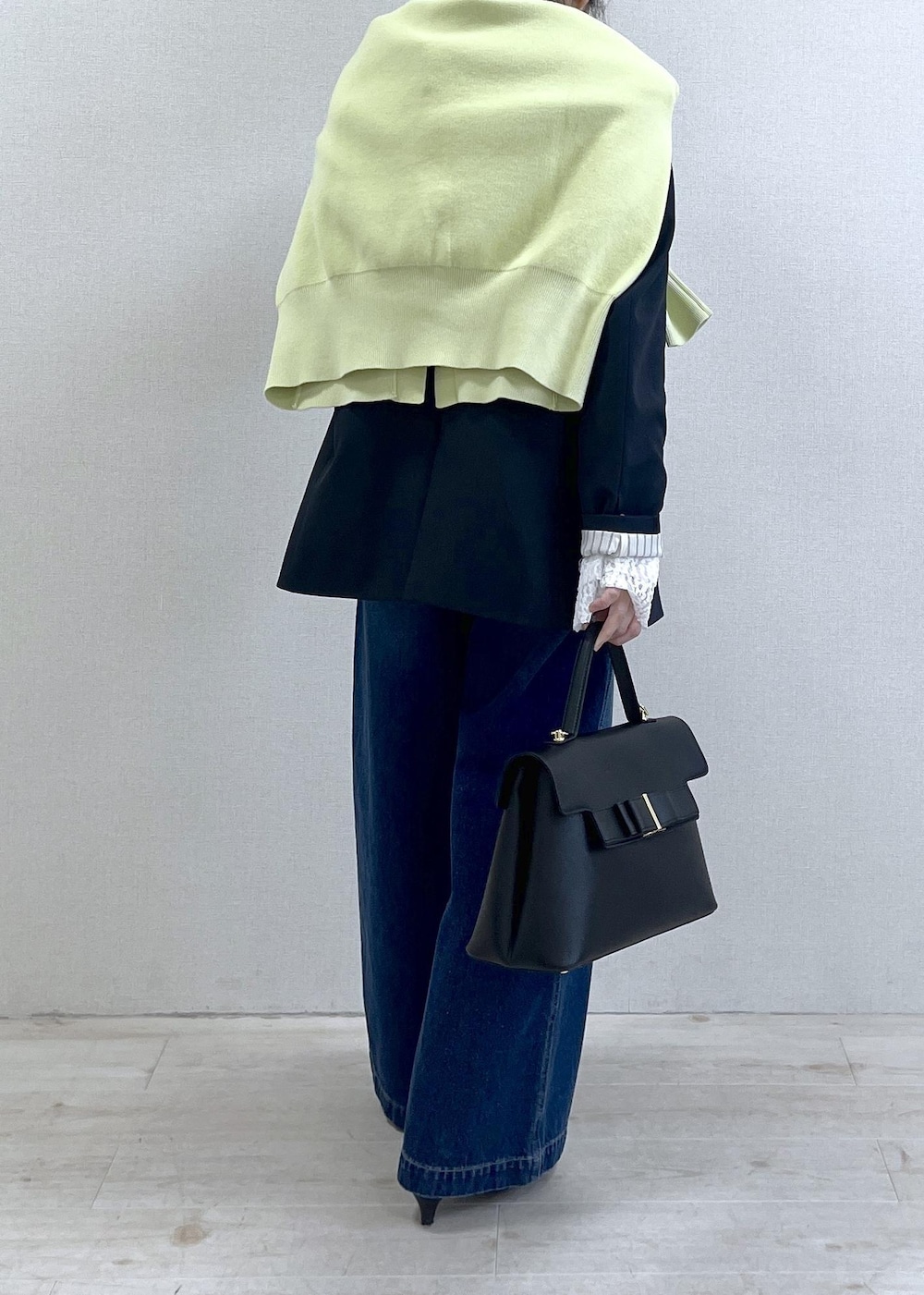 ブルー系のテーラードジャケット、グリーン系のカーディガン/ボレロ、ブルー系のデニムパンツを着用したレディースの冬コーディネートの5枚目の写真