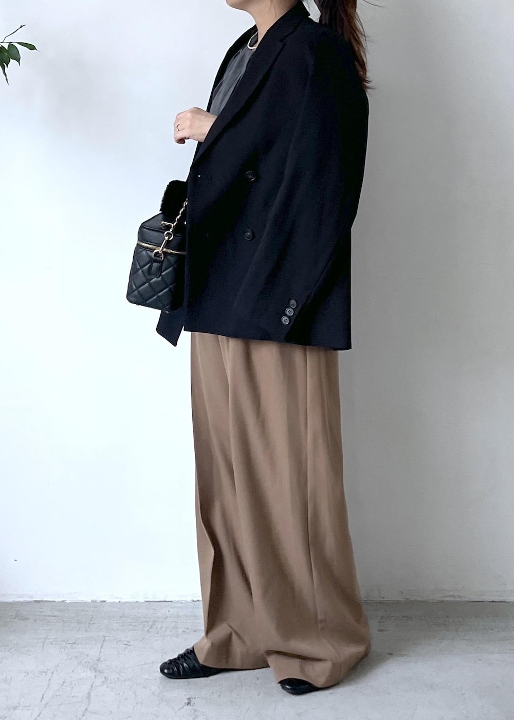 ブラック系のテーラードジャケット、ホワイト系のTシャツ/カットソー、ブラック系のパンプスを着用したレディースの秋コーディネートの4枚目の写真