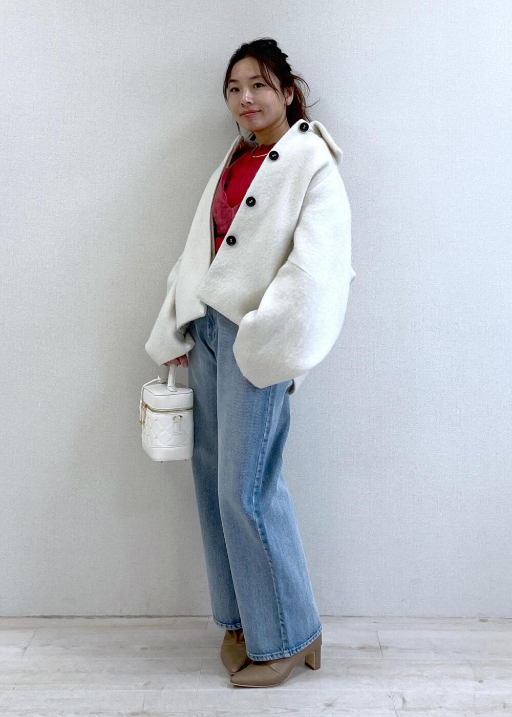 ベージュ系のブーツ、ホワイト系のその他アウター、ブルー系のデニムパンツを着用したレディースの秋コーディネートの6枚目の写真