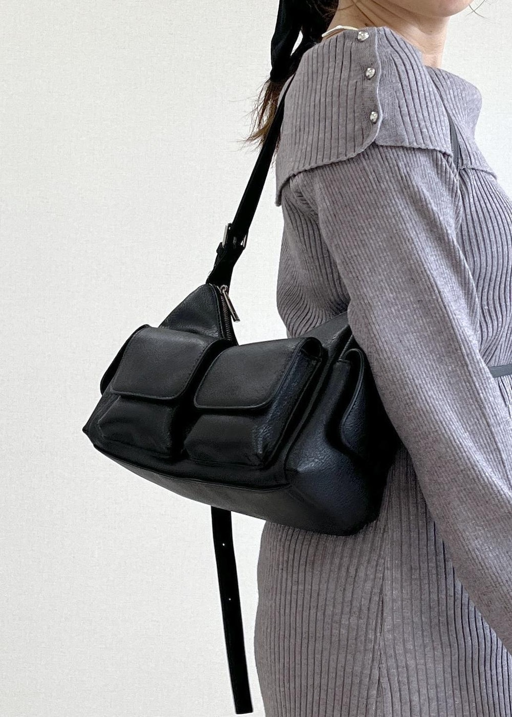 ブラック系のスラックス、ブラック系のショルダーバッグ、ブラック系のブーツを着用したレディースの秋コーディネートの7枚目の写真