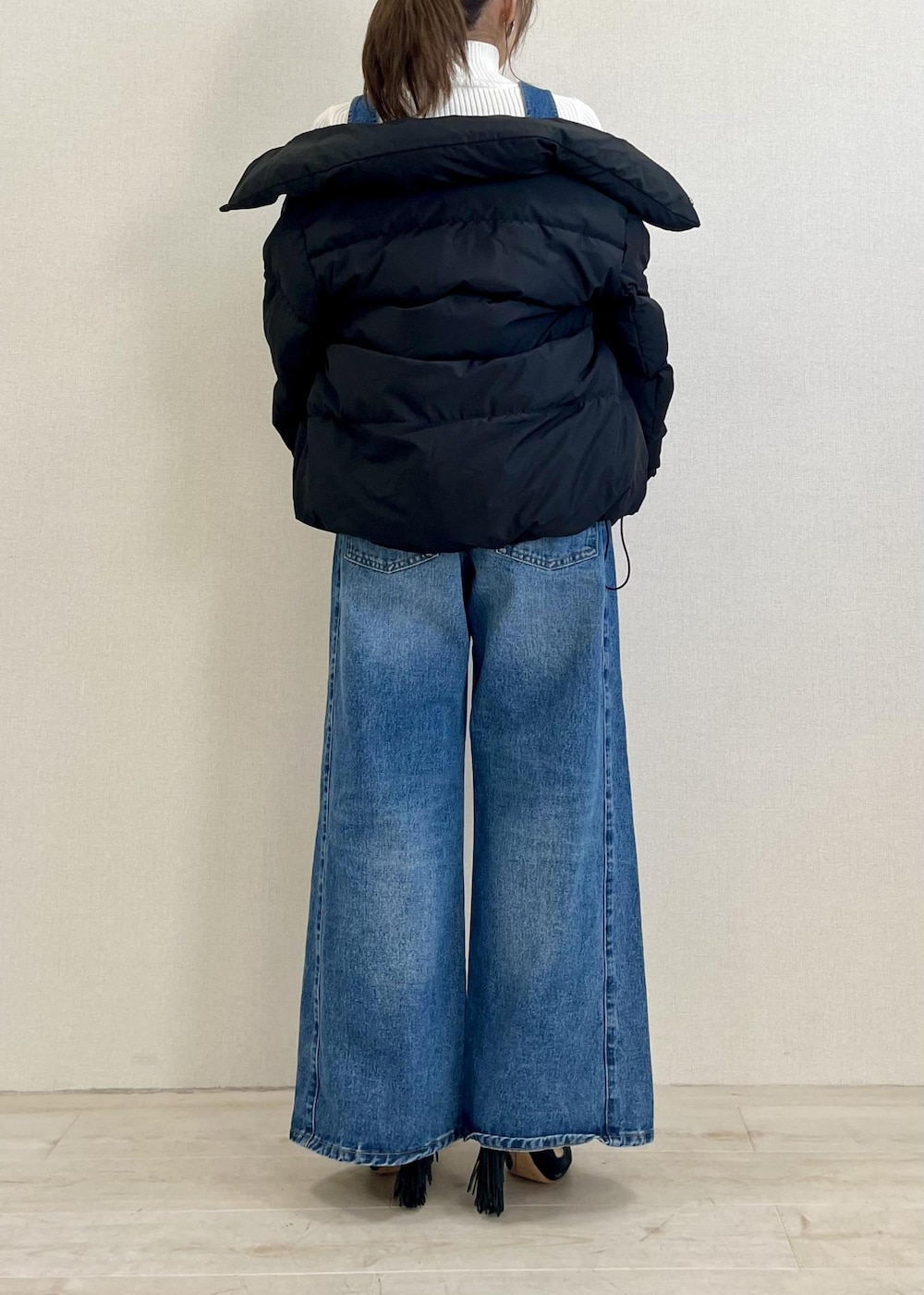 ブラック系のダウンジャケット/コート、シルバー系のショルダーバッグ、ホワイト系のニット/セーターを着用したレディースの冬コーディネートの3枚目の写真