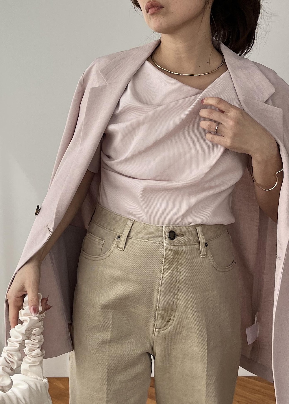 ホワイト系のショルダーバッグ、ピンク系のテーラードジャケット、ベージュ系のデニムパンツを着用したレディースの春コーディネートの9枚目の写真