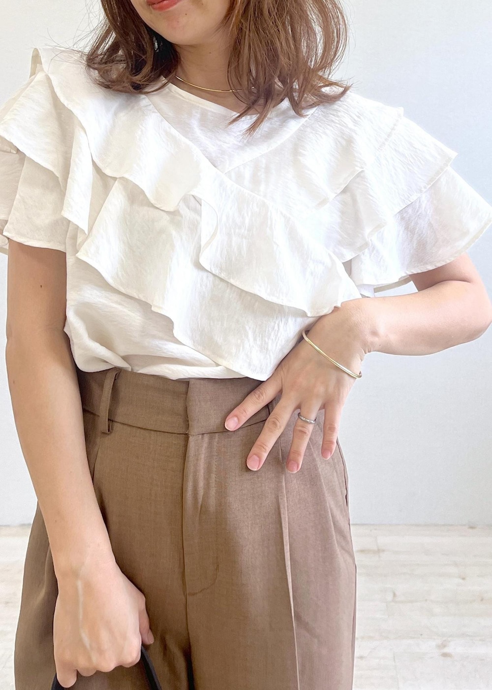 ブラック系のショルダーバッグ、ブラック系のサンダル、ブラウン系のスラックスを着用したレディースの夏コーディネートの6枚目の写真