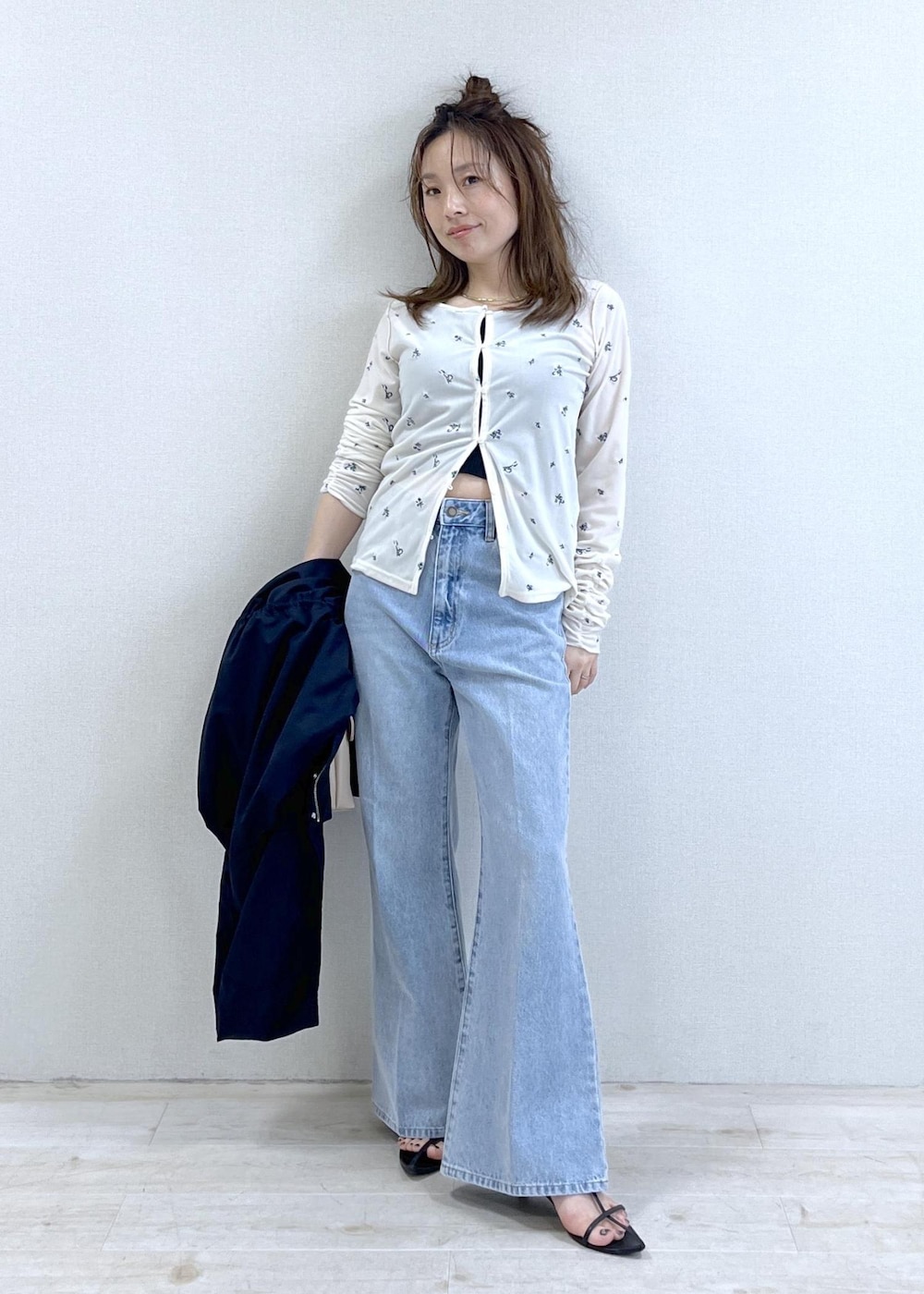 ベージュ系のショルダーバッグ、ブルー系のナイロンジャケット、ブラック系のキャミソールを着用したレディースの春コーディネートの7枚目の写真