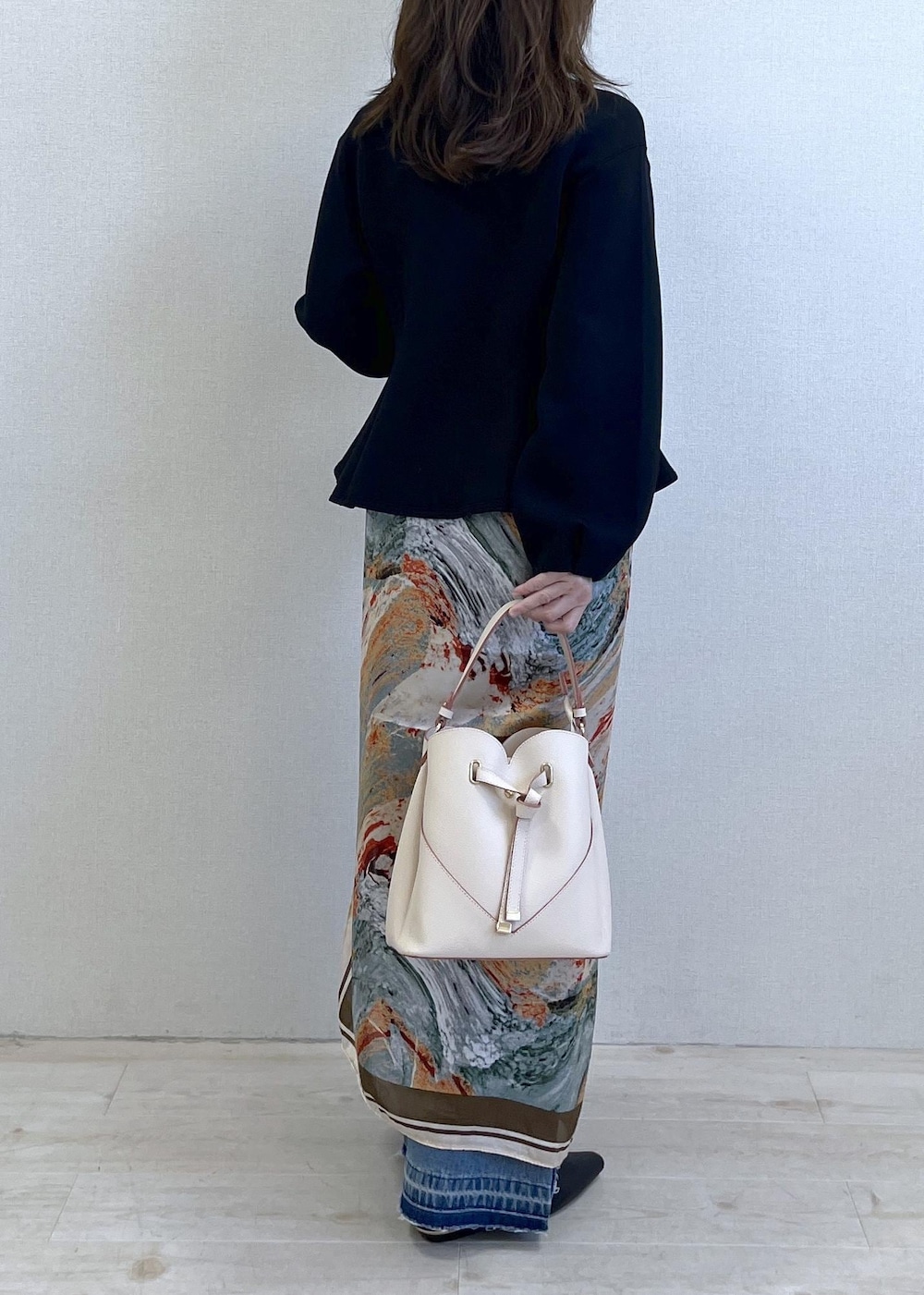 ベージュ系のショルダーバッグ、ブラック系のパンプス、ホワイト系のキャミソールを着用したレディースの春コーディネートの9枚目の写真