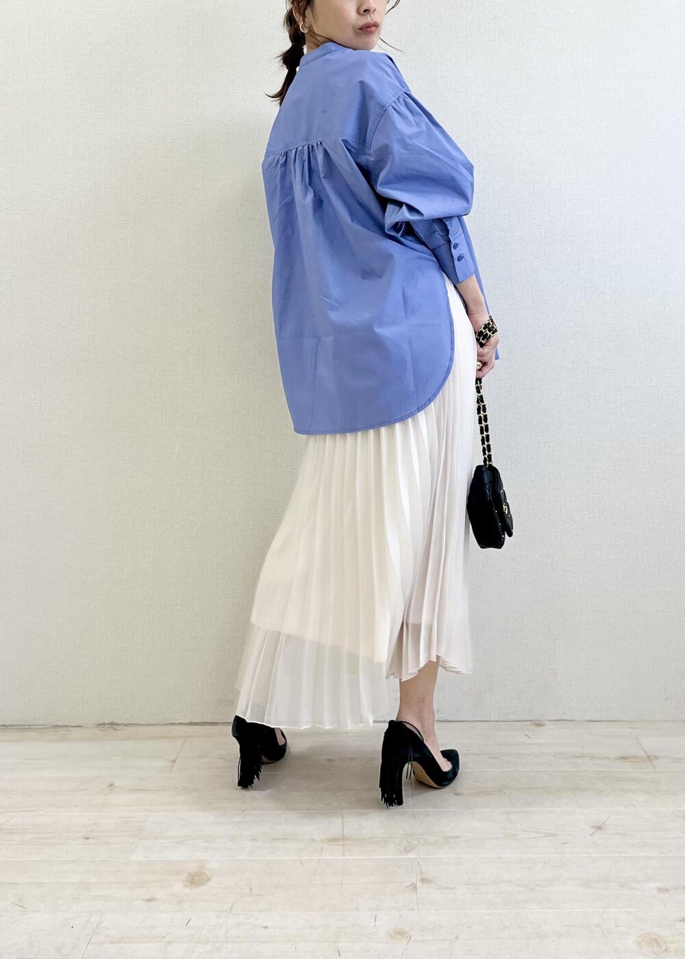 ブラック系のショルダーバッグ、ブルー系のシャツ/ブラウス、ホワイト系のスカートを着用したレディースの春コーディネートの3枚目の写真