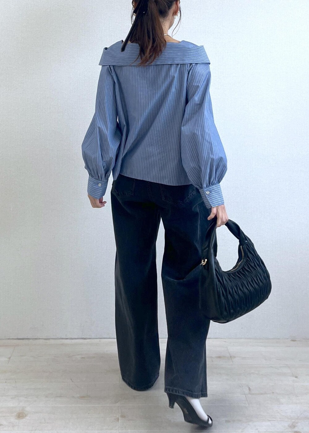 ブルー系のシャツ/ブラウス、グレー系のデニムパンツ、ブラック系のハンドバッグを着用したレディースの秋コーディネートの8枚目の写真