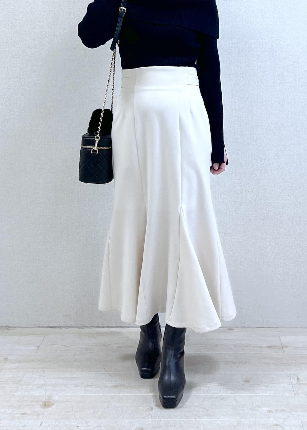 ブラック系のニット/セーター、ブラック系のダウンジャケット/コート、ブラック系のブーツを着用したレディースの冬コーディネートの9枚目の写真