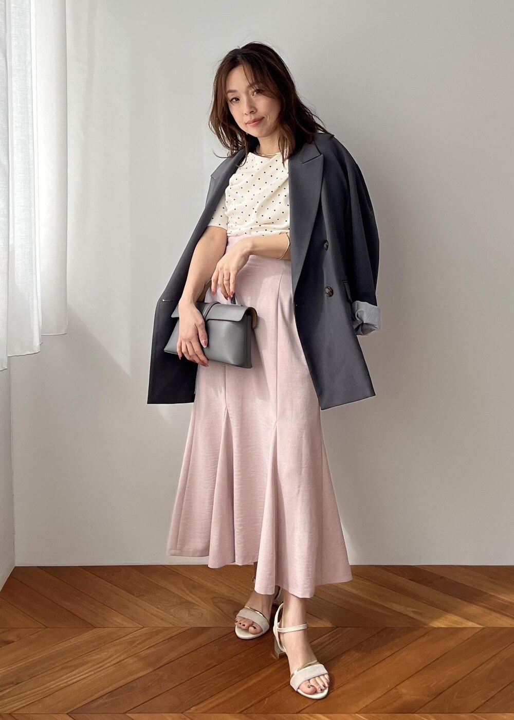 グレー系のショルダーバッグ、グレー系のテーラードジャケット、ピンク系のスカートを着用したレディースの春コーディネートの10枚目の写真