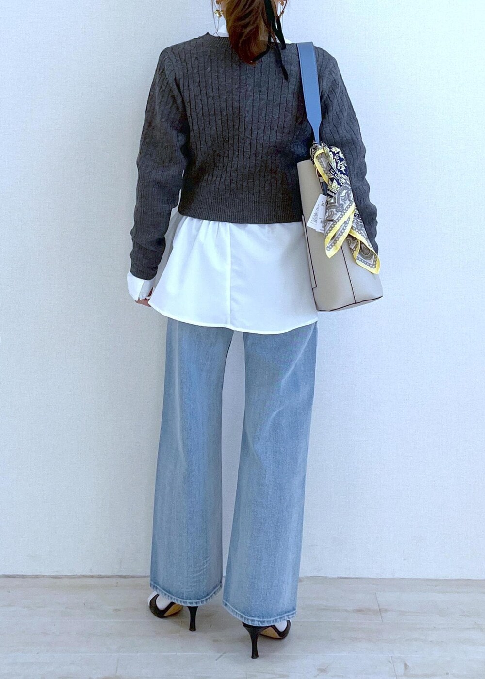 ベージュ系のショルダーバッグ、ホワイト系のシャツ/ブラウス、ブルー系のデニムパンツを着用したレディースの冬コーディネートの4枚目の写真