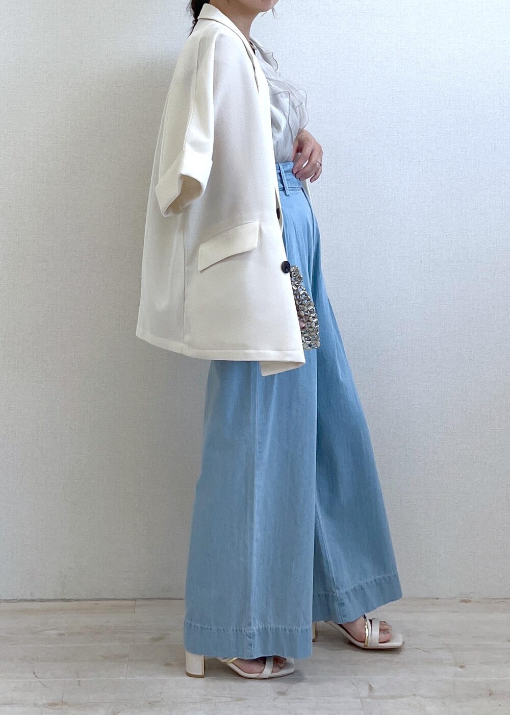 ホワイト系のサンダル、シルバー系のハンドバッグ、ブルー系のデニムパンツを着用したレディースの夏コーディネートの9枚目の写真