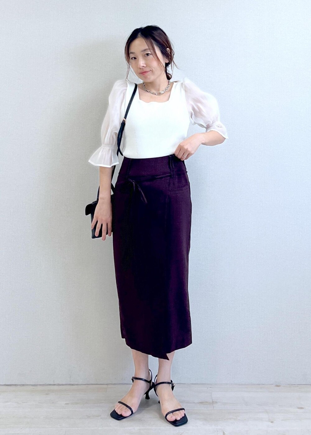 ブラック系のサンダル、ホワイト系のTシャツ/カットソー、ブラウン系のスカートを着用したレディースの夏コーディネートの4枚目の写真