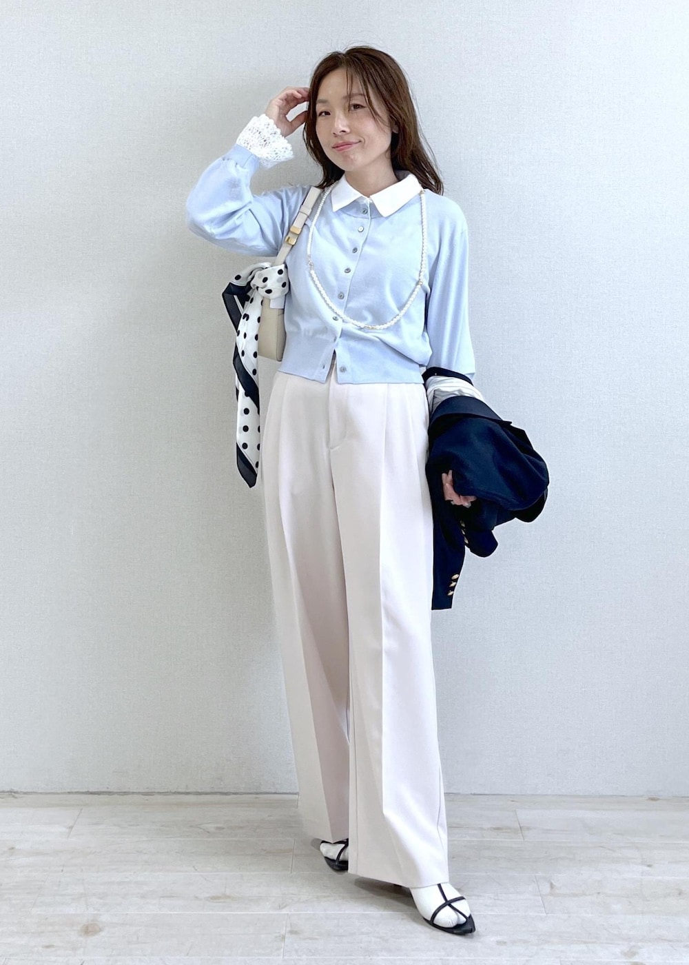 ホワイト系のショルダーバッグ、ブルー系のテーラードジャケット、ベージュ系のその他パンツを着用したレディースの春コーディネートの7枚目の写真