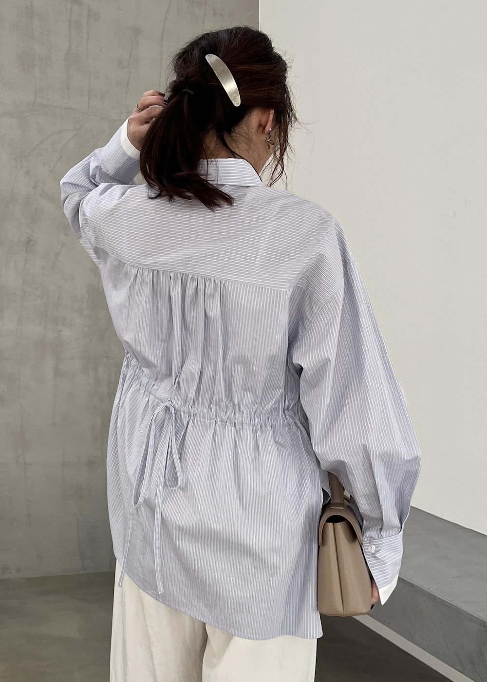 ベージュ系のショルダーバッグ、ブラック系のパンプス、ホワイト系のその他パンツを着用したレディースの冬コーディネートの8枚目の写真