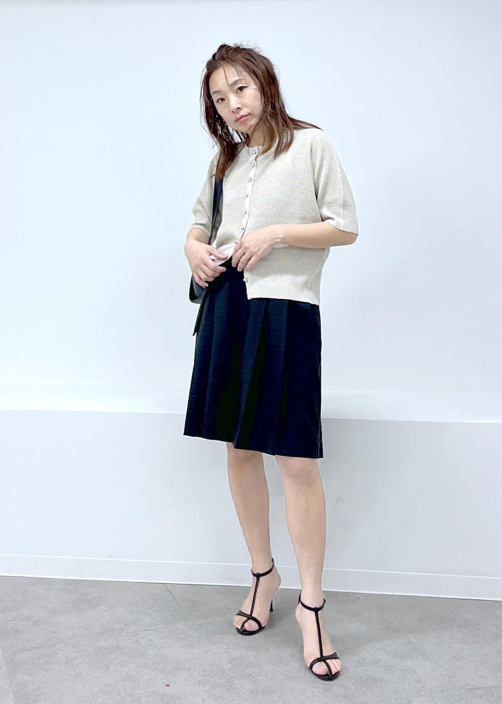ブラック系のその他パンツ、ブラック系のショルダーバッグ、ホワイト系のカーディガン/ボレロを着用したレディースの春コーディネートの7枚目の写真