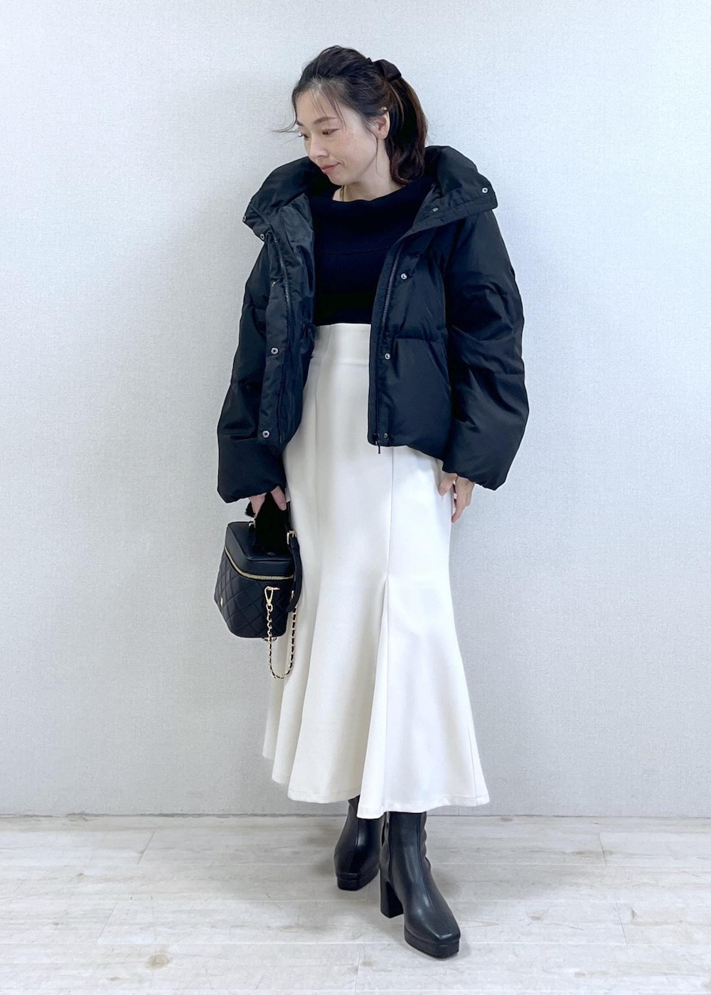 ブラック系のニット/セーター、ブラック系のダウンジャケット/コート、ブラック系のブーツを着用したレディースの冬コーディネートの5枚目の写真