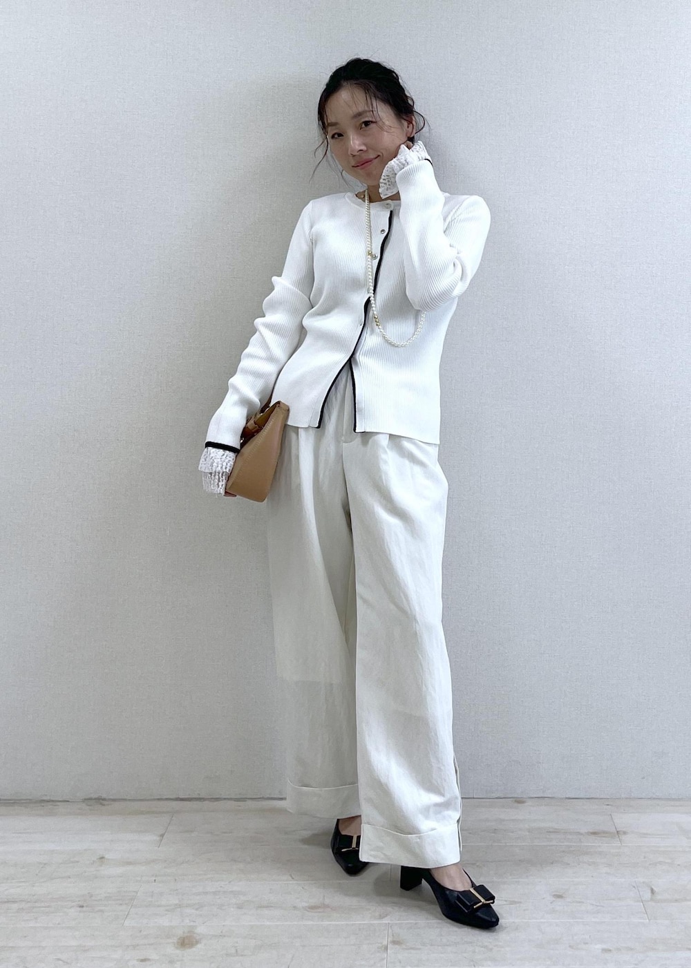 ブラック系のパンプス、ブルー系のテーラードジャケット、イエロー系のショルダーバッグを着用したレディースの冬コーディネートの6枚目の写真