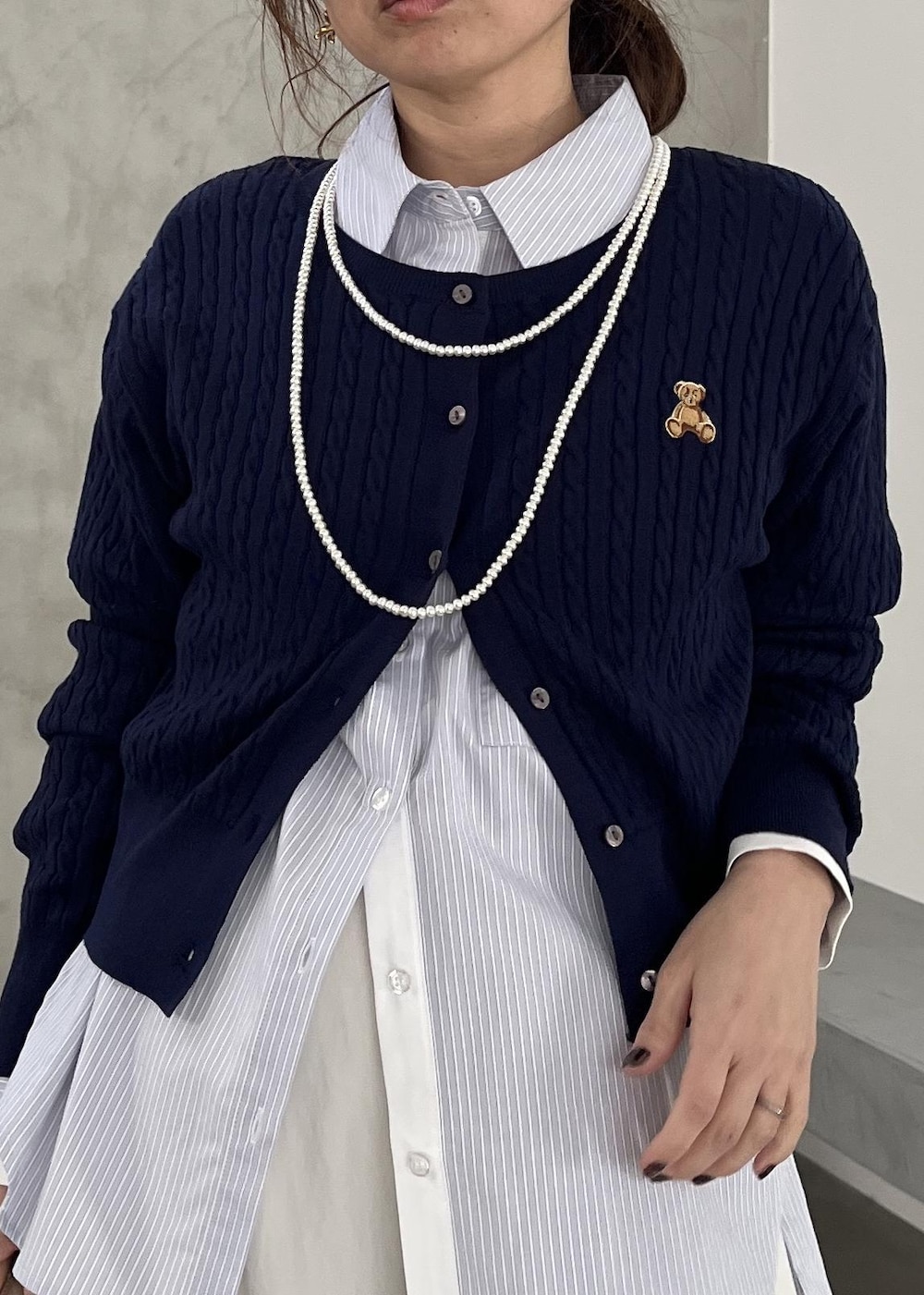 ベージュ系のショルダーバッグ、ブラック系のパンプス、ホワイト系のその他パンツを着用したレディースの冬コーディネートの5枚目の写真