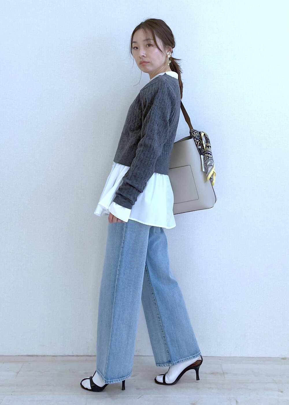 ベージュ系のショルダーバッグ、ホワイト系のシャツ/ブラウス、ブルー系のデニムパンツを着用したレディースの冬コーディネートの2枚目の写真