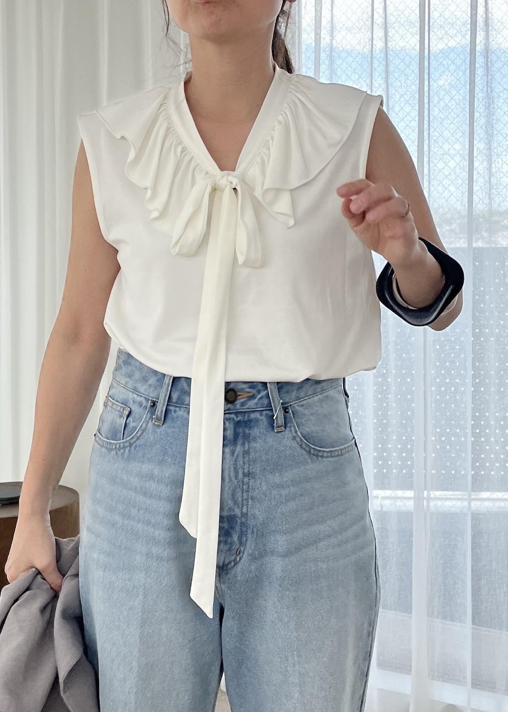 ブルー系のデニムパンツ、シルバー系のサンダル、グレー系のテーラードジャケットを着用したレディースの夏コーディネートの9枚目の写真