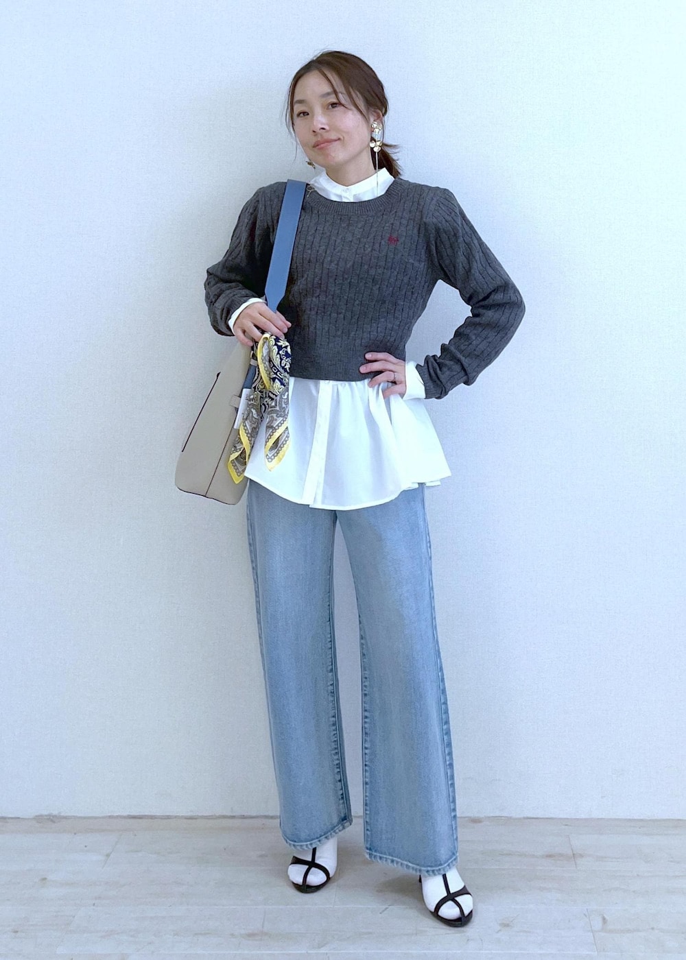 ベージュ系のショルダーバッグ、ホワイト系のシャツ/ブラウス、ブルー系のデニムパンツを着用したレディースの冬コーディネートの6枚目の写真