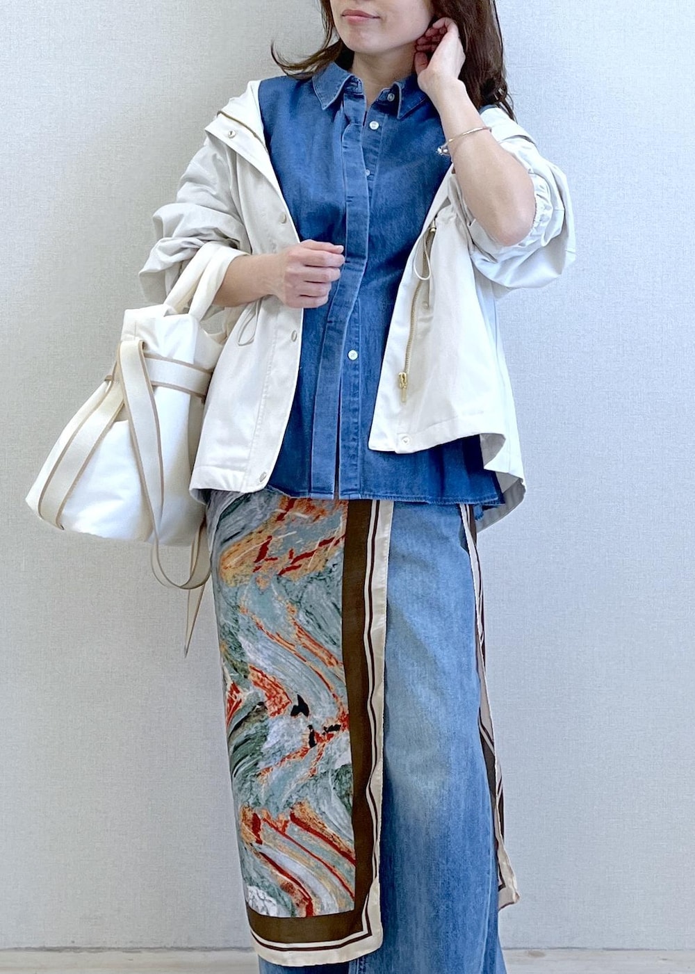 ブラック系のパンプス、ホワイト系のトートバッグ、ホワイト系のナイロンジャケットを着用したレディースの春コーディネートの7枚目の写真