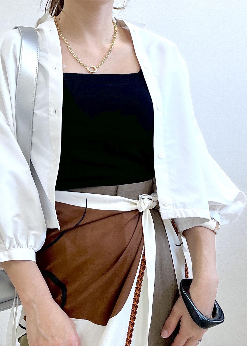 ブラック系のキャミソール、シルバー系のショルダーバッグ、ブラック系のサンダルを着用したレディースの春コーディネートの6枚目の写真