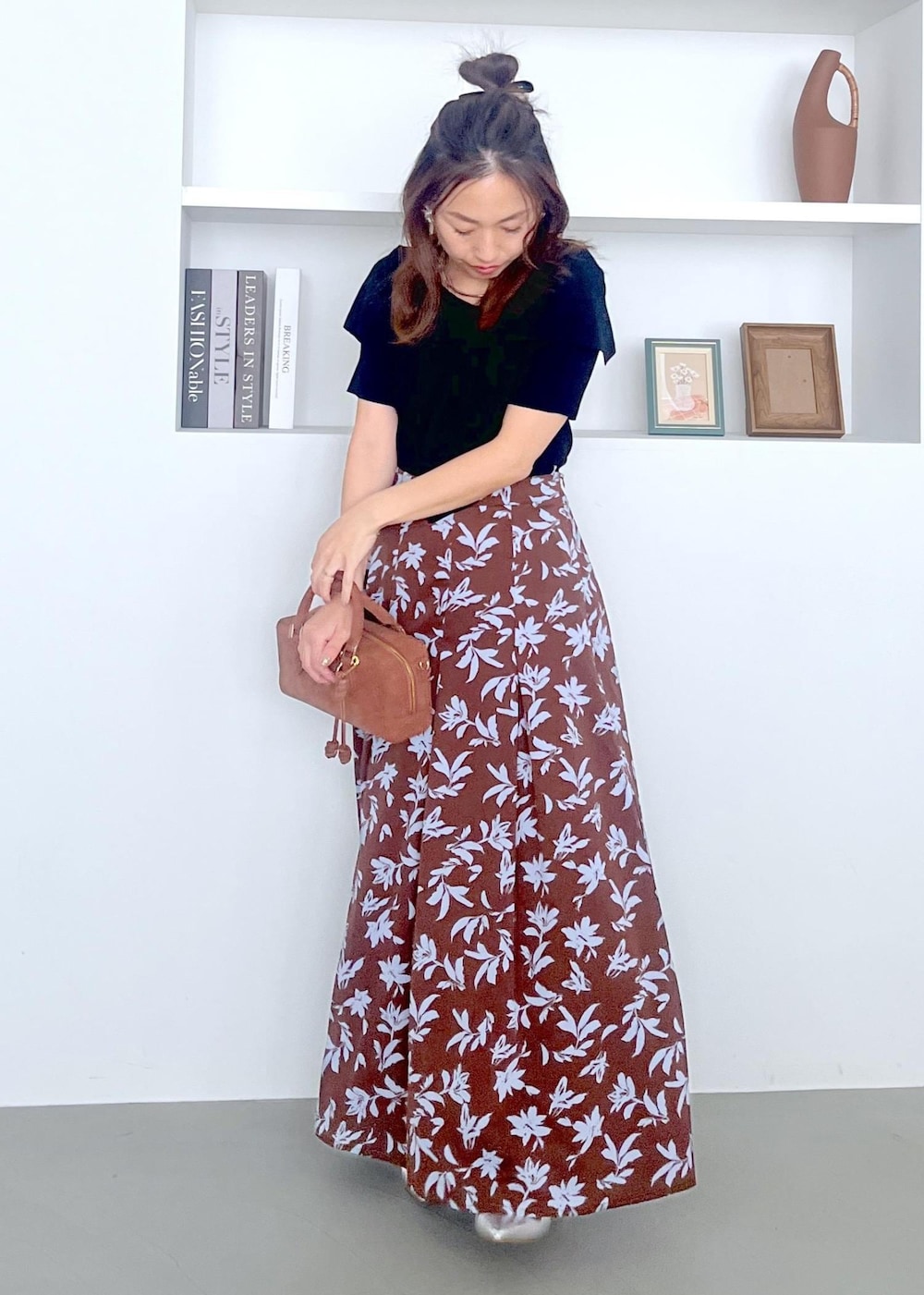 シルバー系のパンプス、ブラウン系のボストンバッグ、ブラウン系のスカートを着用したレディースの夏コーディネートの7枚目の写真