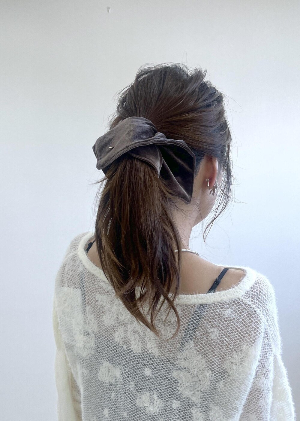 ブラック系のローファー、ホワイト系のニット/セーター、ブルー系のデニムパンツを着用したレディースの秋コーディネートの6枚目の写真