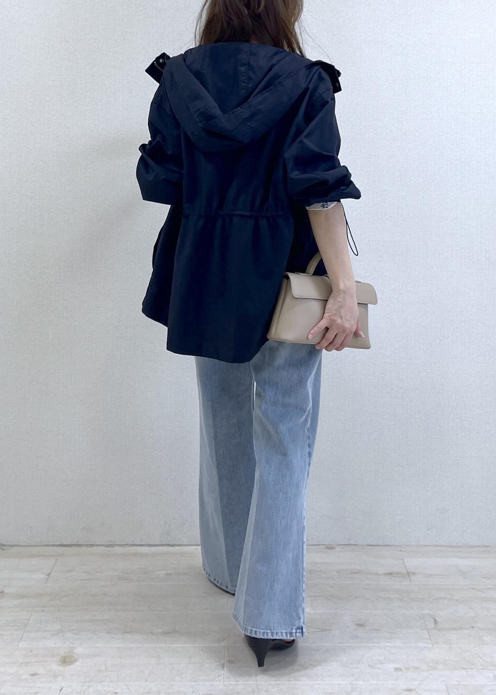 ベージュ系のショルダーバッグ、ブルー系のナイロンジャケット、ブラック系のキャミソールを着用したレディースの春コーディネートの4枚目の写真