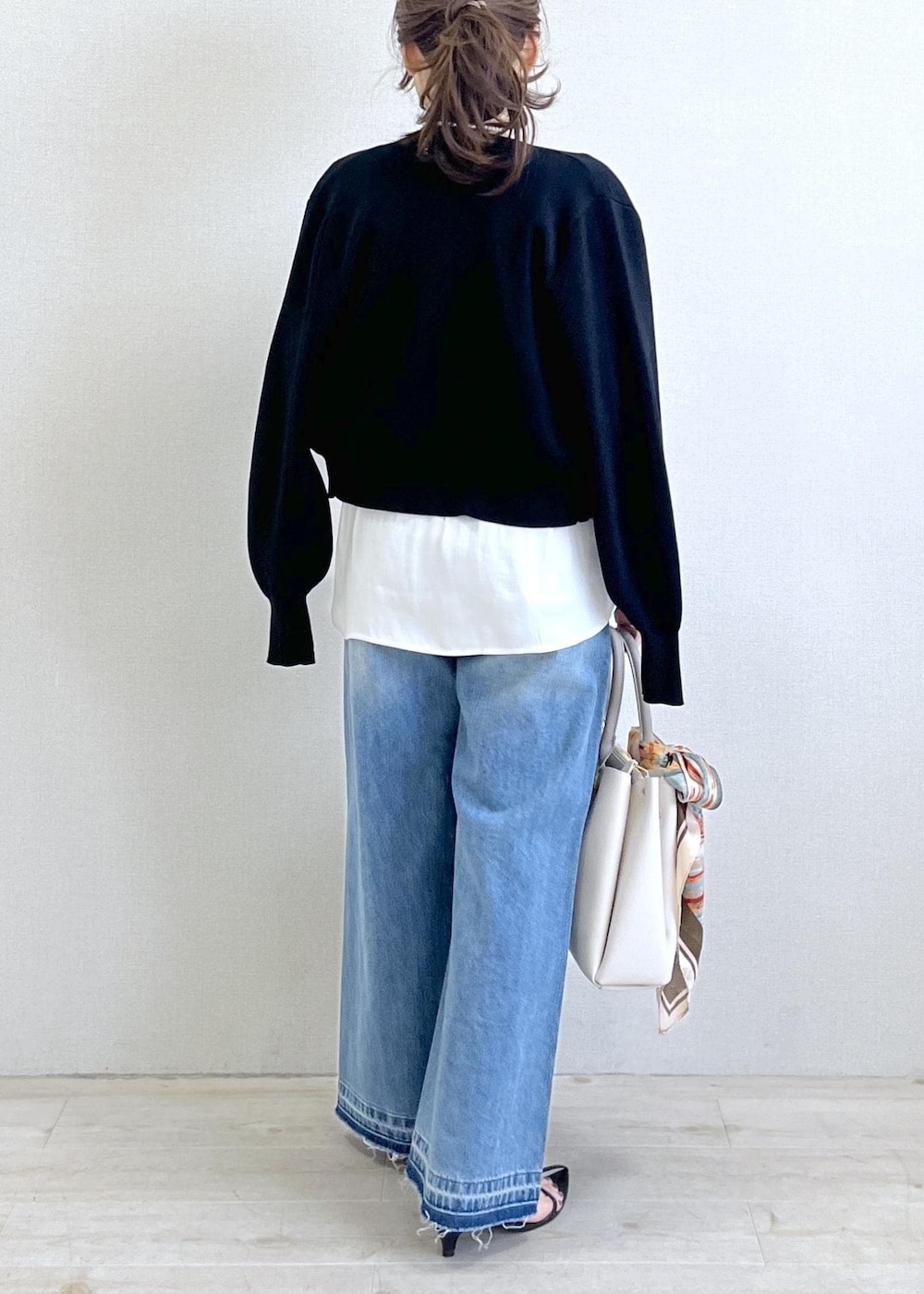 ブラック系のキャミソール、ブルー系のデニムパンツ、ブラック系のカーディガン/ボレロを着用したレディースの春コーディネートの4枚目の写真