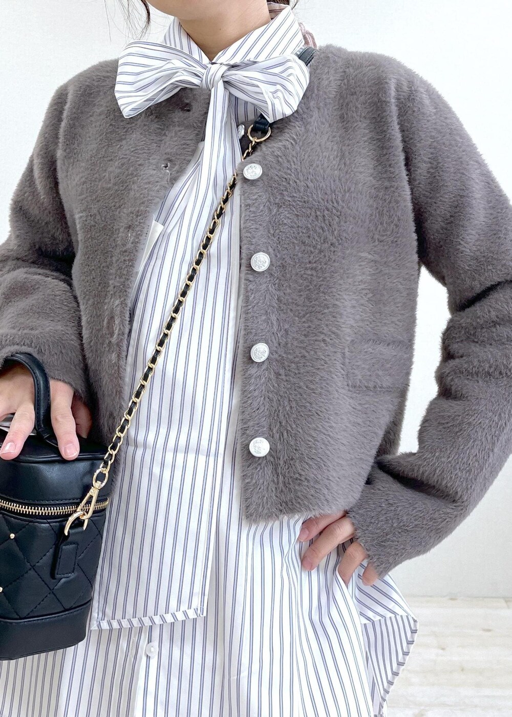 ブラック系のブーツ、ホワイト系のシャツ/ブラウス、ブラウン系のカーディガン/ボレロを着用したレディースの冬コーディネートの5枚目の写真