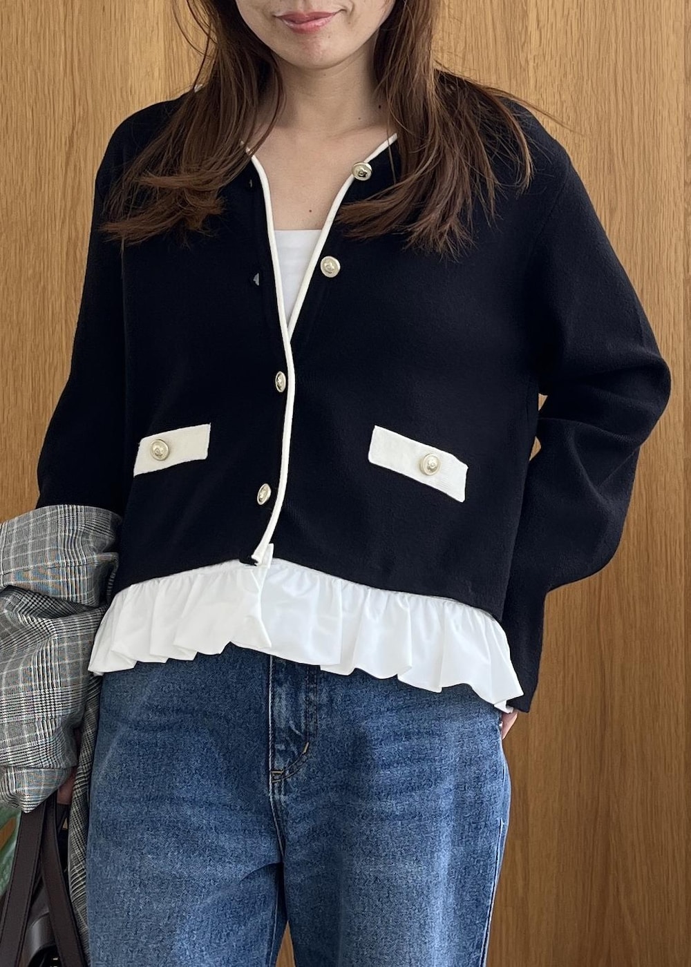 グレー系のテーラードジャケット、ブラウン系のビジネスバッグ、ブルー系のデニムパンツを着用したレディースの秋コーディネートの4枚目の写真