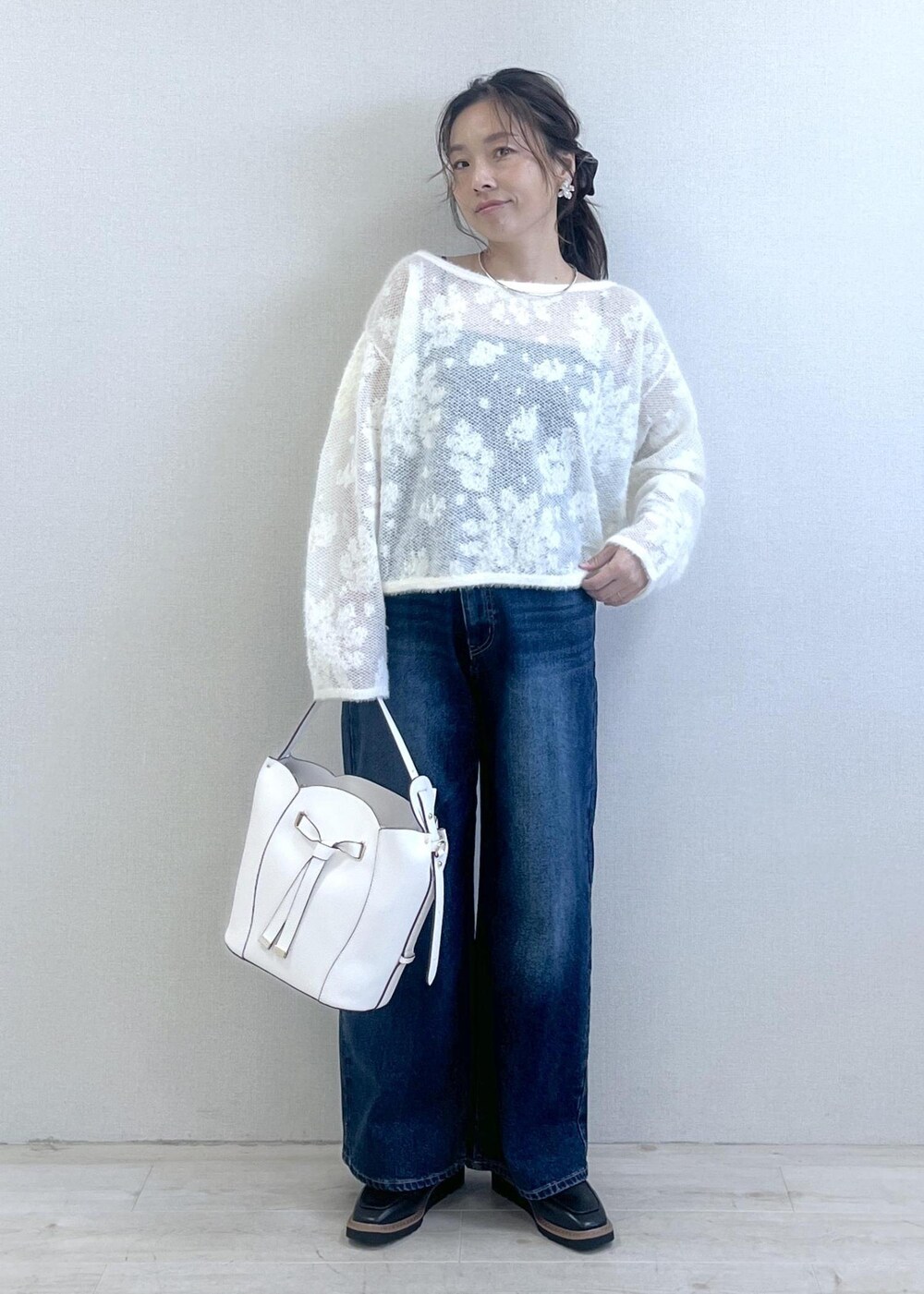 ブラック系のローファー、ホワイト系のニット/セーター、ブルー系のデニムパンツを着用したレディースの秋コーディネートの10枚目の写真