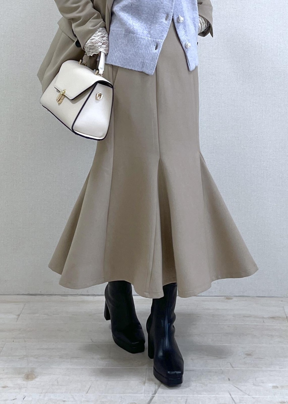 ブラック系のブーツ、ベージュ系のスカート、パープル系のカーディガン/ボレロを着用したレディースの秋コーディネートの9枚目の写真