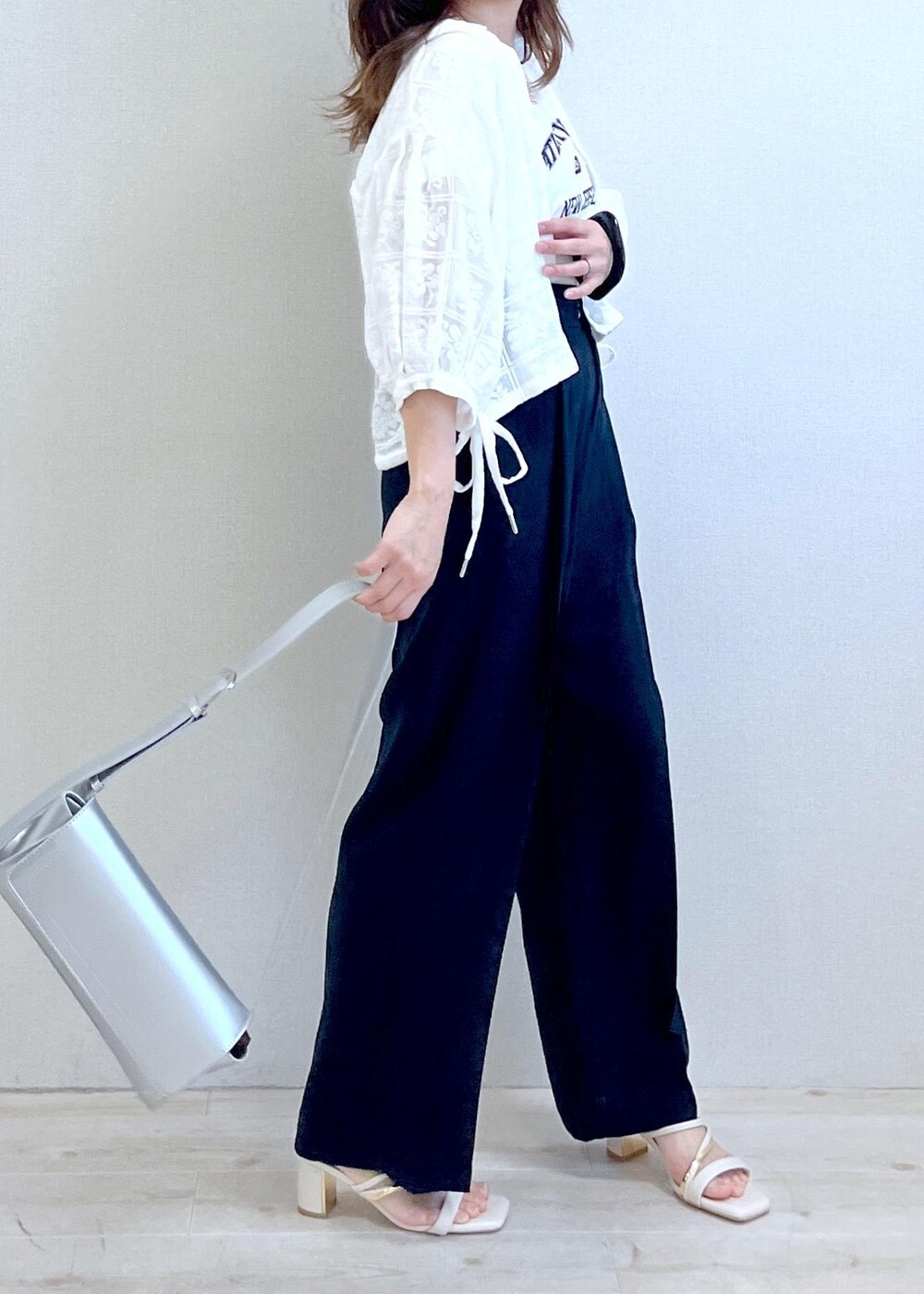 シルバー系のショルダーバッグ、ホワイト系のTシャツ/カットソー、ホワイト系のサンダルを着用したレディースの春コーディネートの4枚目の写真