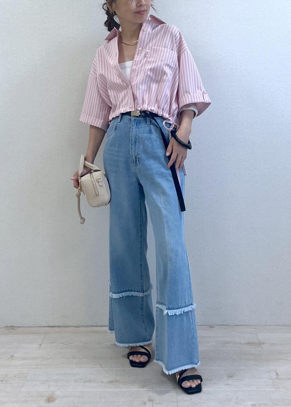 ブラック系のサンダル、ブルー系のデニムパンツ、ベージュ系のボストンバッグを着用したレディースの夏コーディネートの8枚目の写真